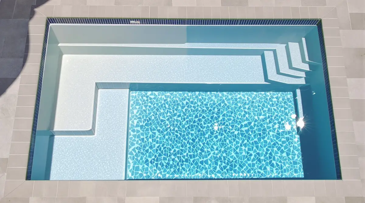 Crystal-clear fiberglass pool with smooth gelcoat finish — low maintenance and low chemical use