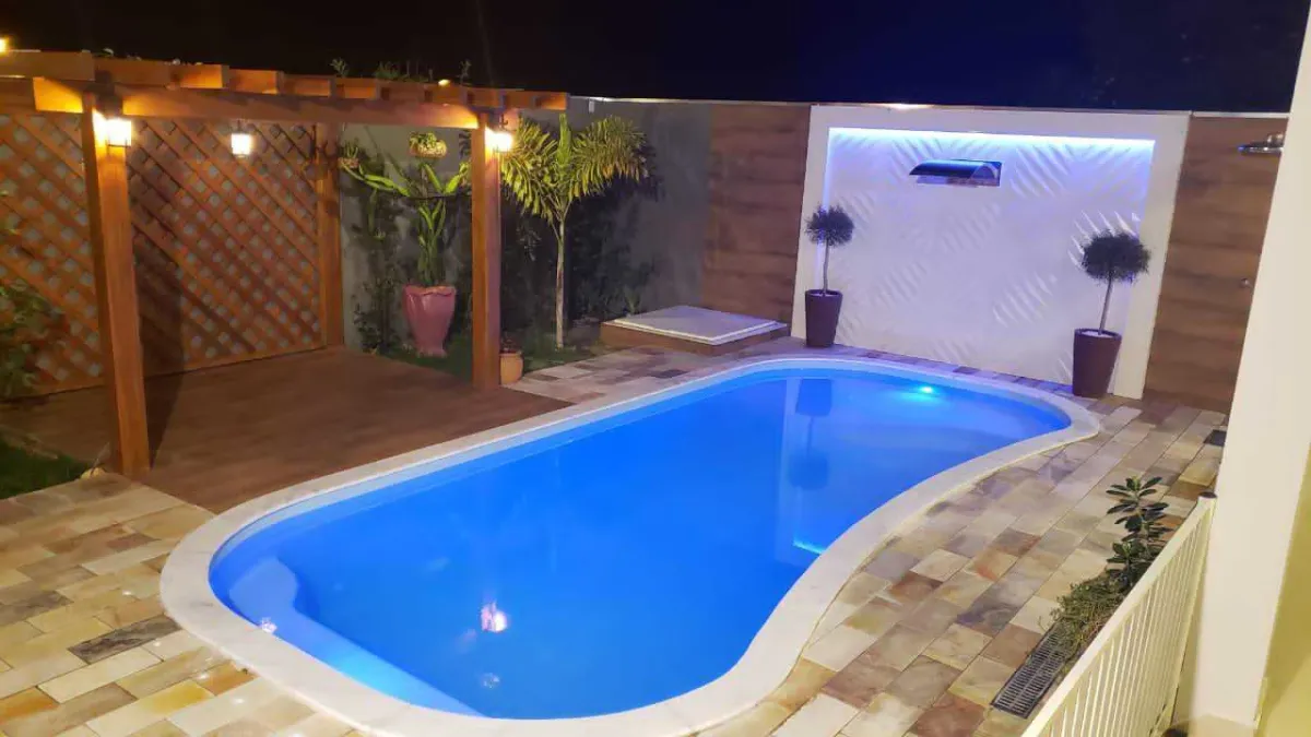 Fiberglass pool installation in progress — shell placed and backfill compaction underway
